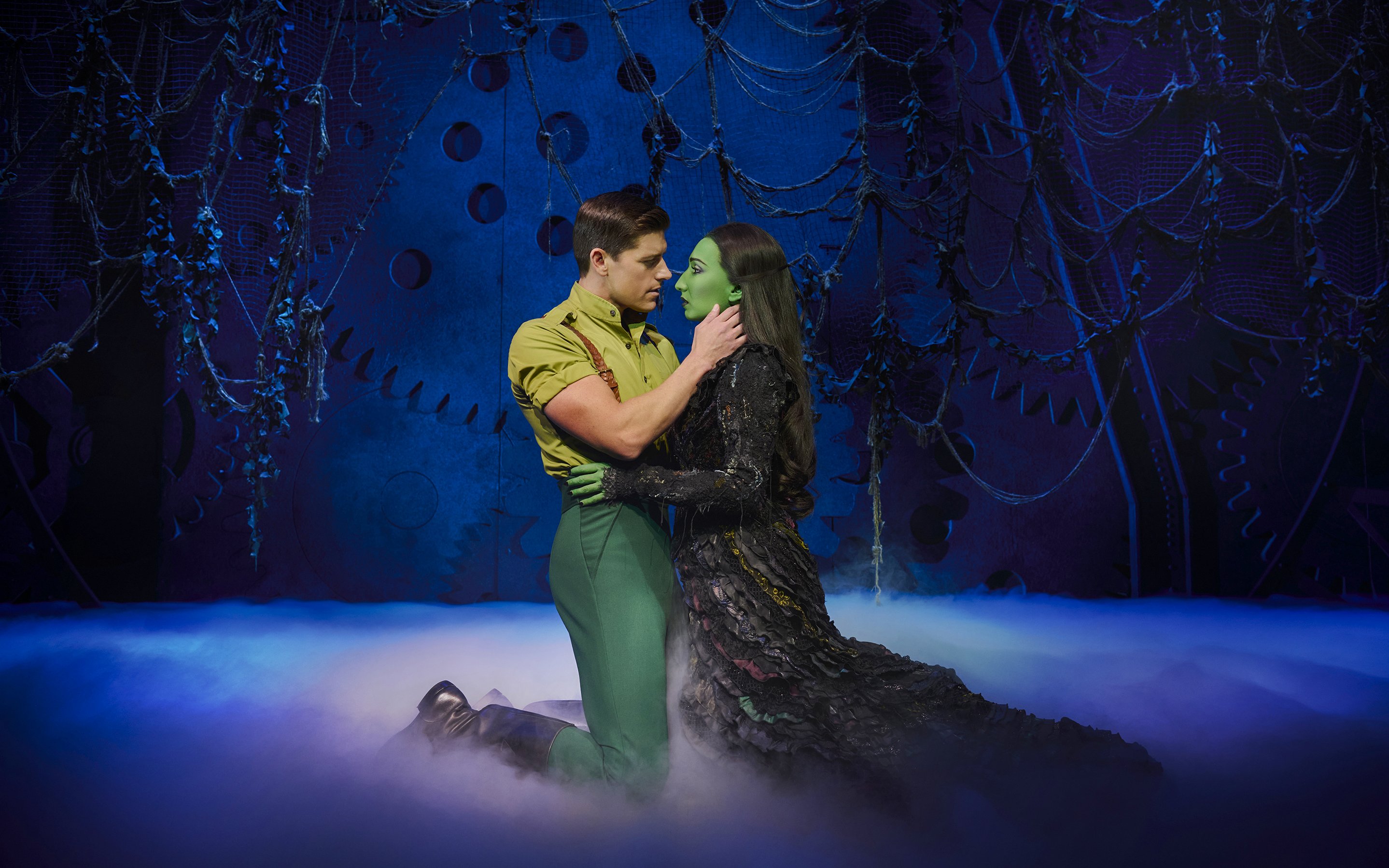 Actors in a dramatic scene from the musical Wicked on stage.