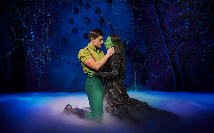 Actors in a dramatic scene from the musical Wicked on stage.
