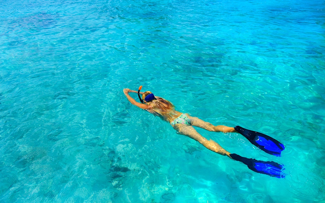 Snorkeler in clear waters of Rose Island, Green Cays, Nassau, Bahamas.