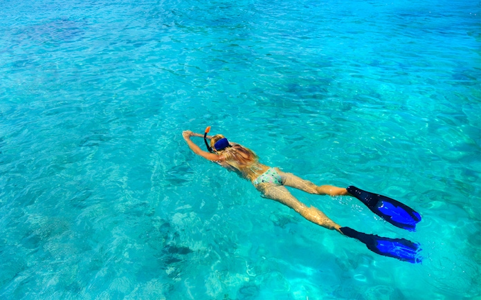 Snorkeler in clear waters of Rose Island, Green Cays, Nassau, Bahamas.