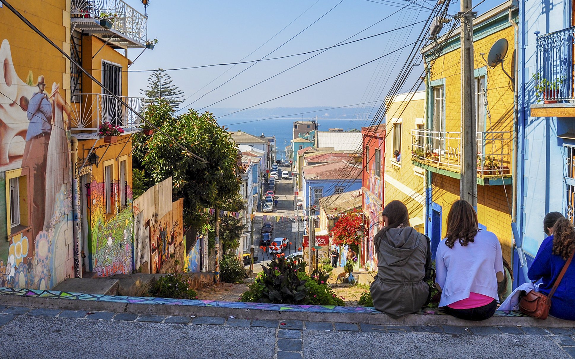 Tourists sitting on a colorful street enjoying the view of Valparaíso, Chile.
