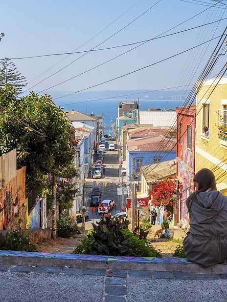 Tourists sitting on a colorful street enjoying the view of Valparaíso, Chile.