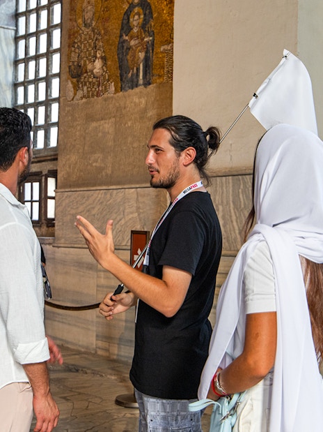 Tour guide explaining mosaics to visitors inside Hagia Sophia, Istanbul.