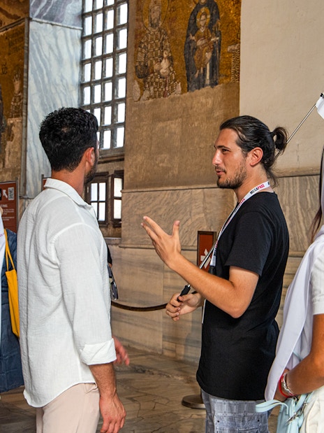 Tour guide explaining mosaics to visitors inside Hagia Sophia, Istanbul.