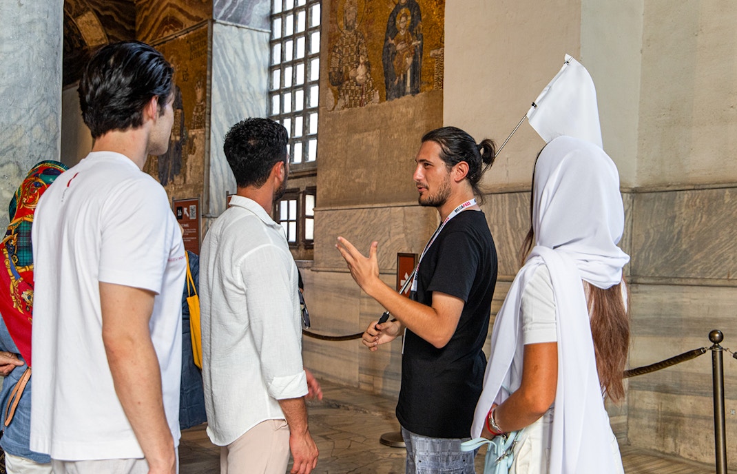 Tour guide explaining mosaics to visitors inside Hagia Sophia, Istanbul.