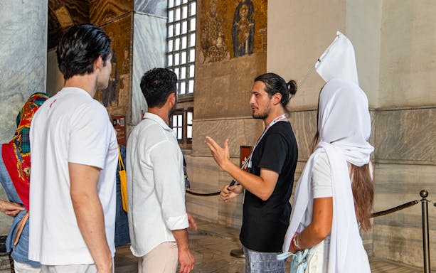 Tour guide explaining mosaics to visitors inside Hagia Sophia, Istanbul.