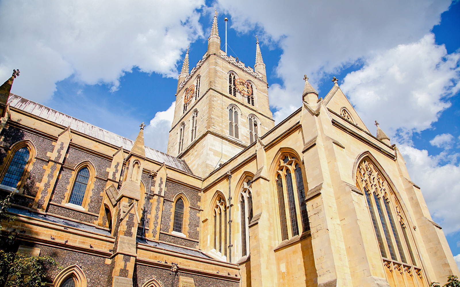 Southwark Cathedral's Gothic architecture under a blue sky, South Bank, London, UK.