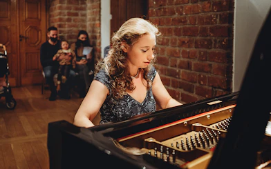 Pianist performing Chopin at Old Town recital with audience in background.