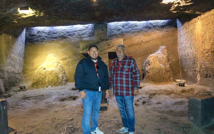 Visitors inside Zipaquira Salt Cathedral, Colombia, standing near illuminated rock formations.