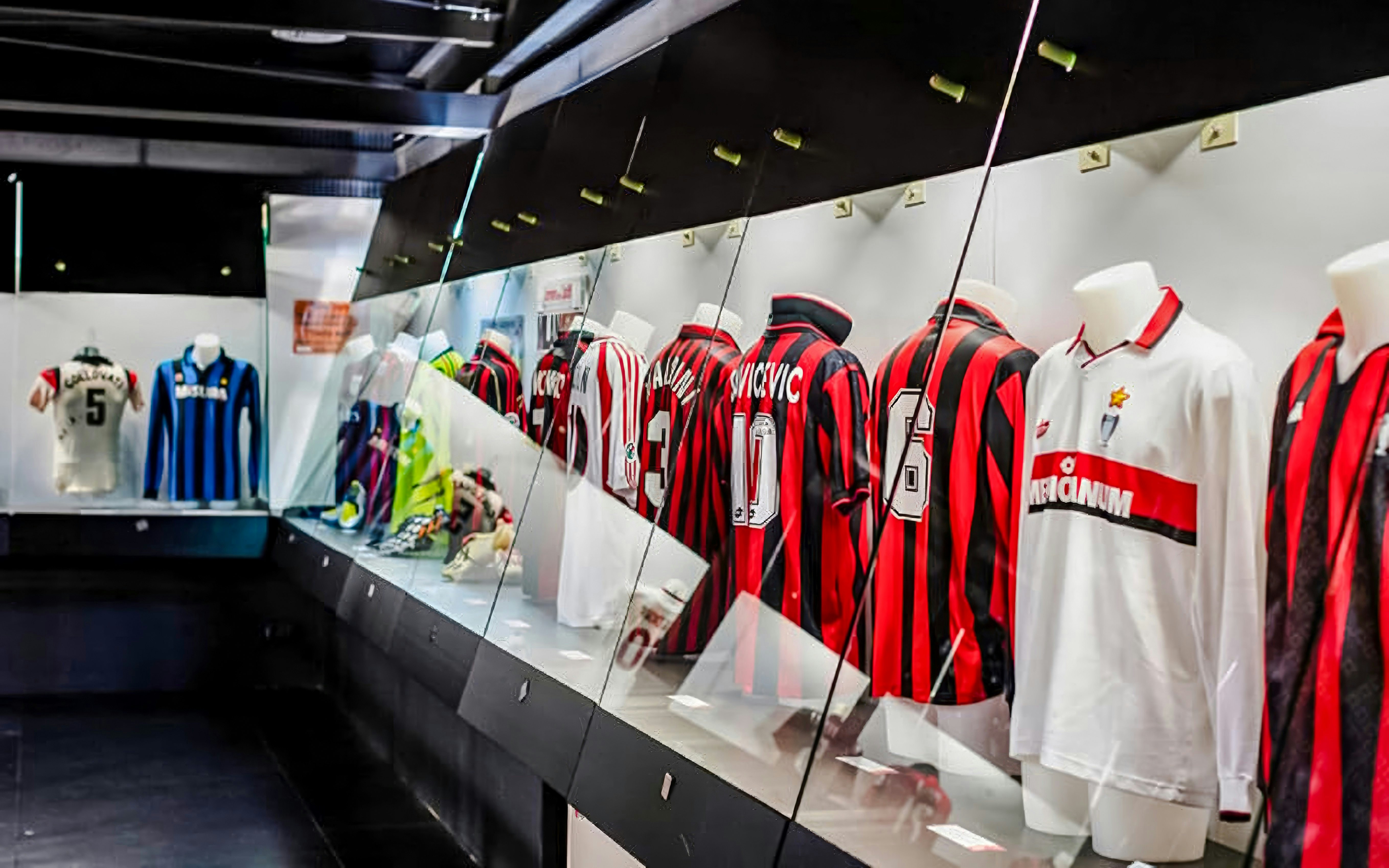 San Siro stadium dressing room with football jerseys on display.