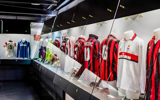 San Siro stadium dressing room with football jerseys on display.