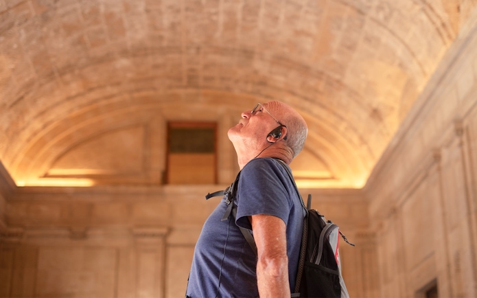 Visitor admiring the vaulted ceiling at Châteaux of Chantilly, France.