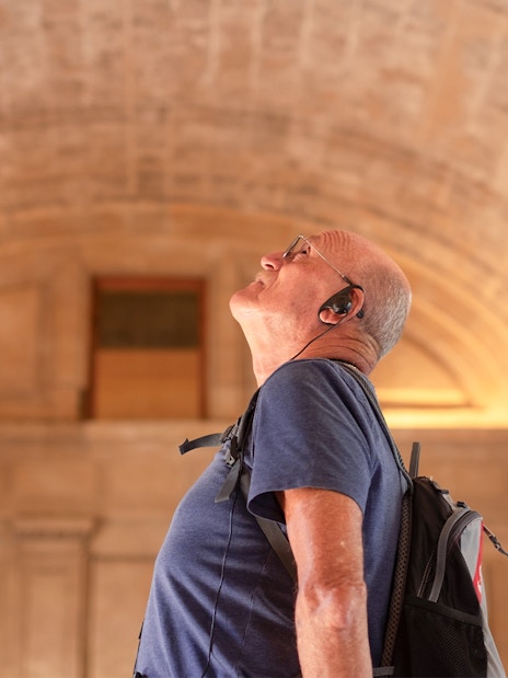 Visitor admiring the vaulted ceiling at Châteaux of Chantilly, France.