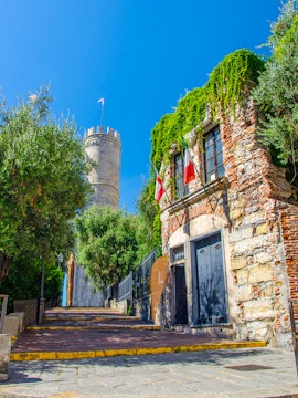 Christopher Columbus' House with ivy-covered walls and nearby tower in Genoa, Italy.