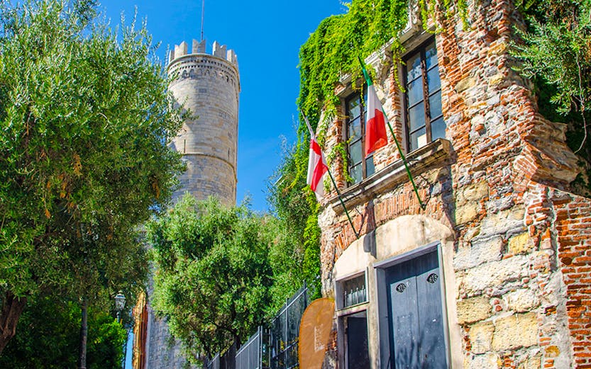 Christopher Columbus' House with ivy-covered walls and nearby tower in Genoa, Italy.