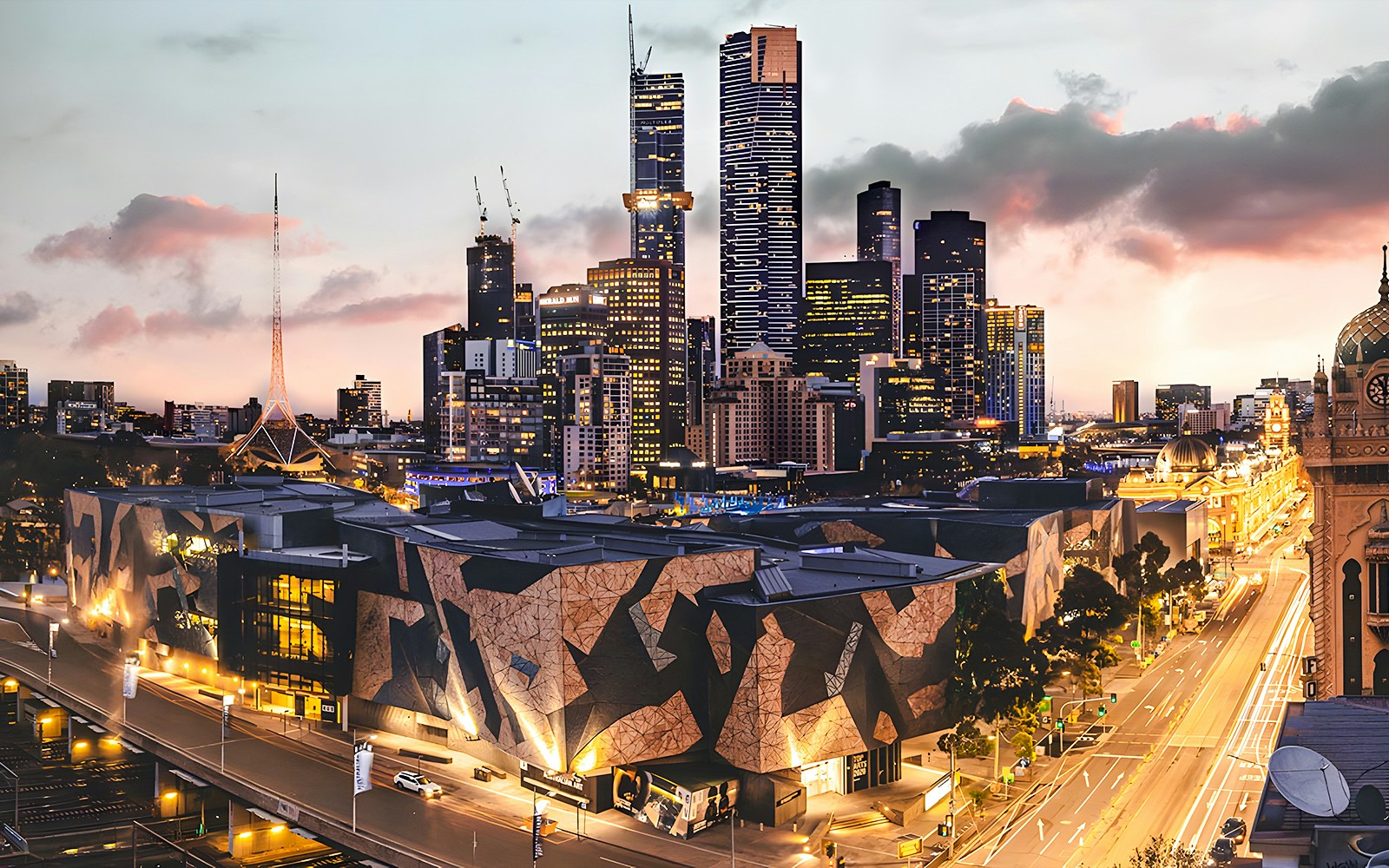 Ian Potter Center at NGV Australia with Melbourne skyline at dusk.