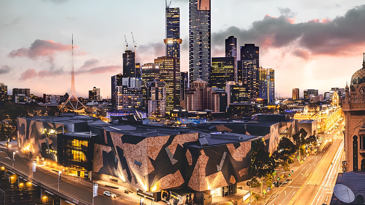 Ian Potter Center at NGV Australia with Melbourne skyline at dusk.