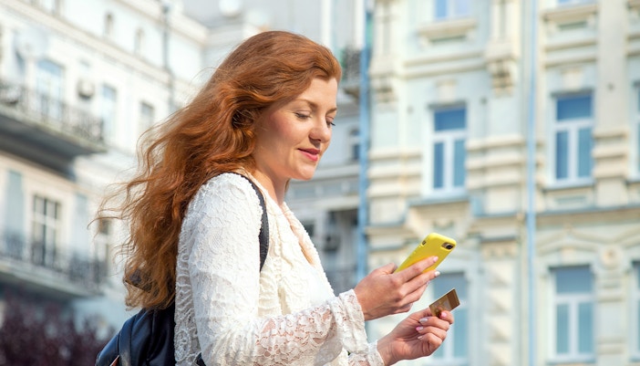 Woman holding travel card and phone at Boboli Gardens, Florence.