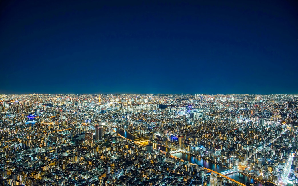 Tokyo cityscape at night from TOKYO SKYTREE Tembo Deck, showcasing illuminated buildings and streets.