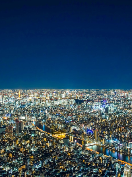 Tokyo cityscape at night from TOKYO SKYTREE Tembo Deck, showcasing illuminated buildings and streets.