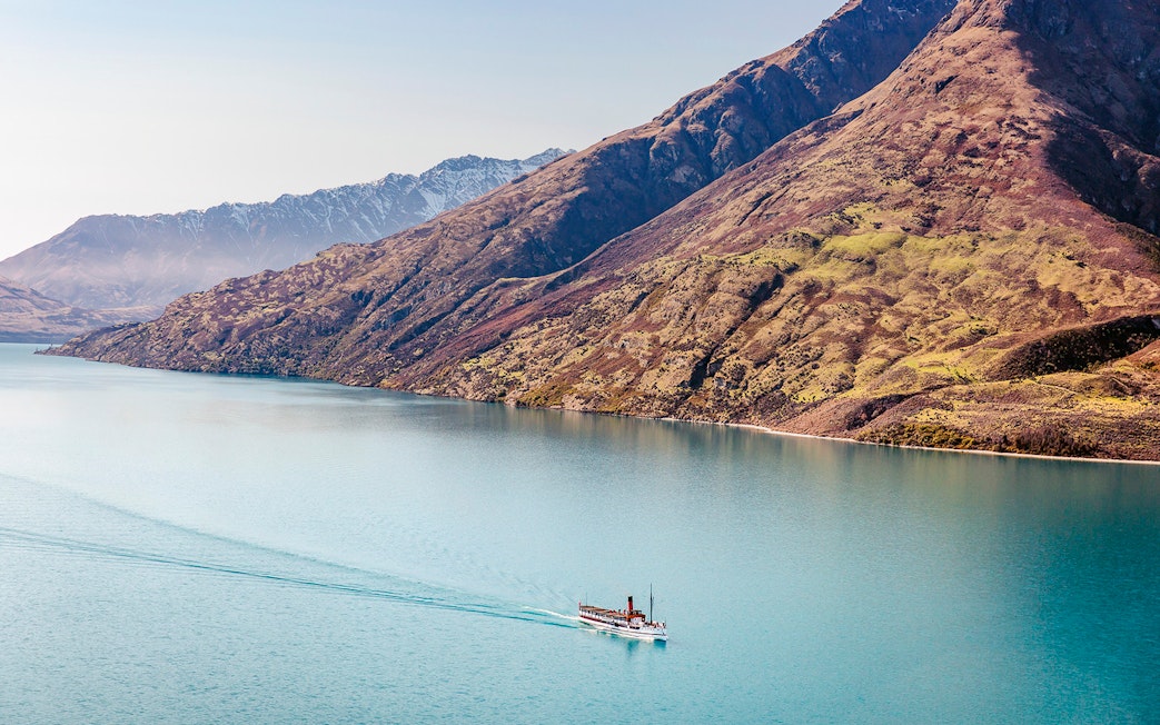 Steamboat cruising on Lake Wakatipu with mountain backdrop.