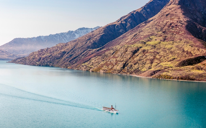 Steamboat cruising on Lake Wakatipu with mountain backdrop.