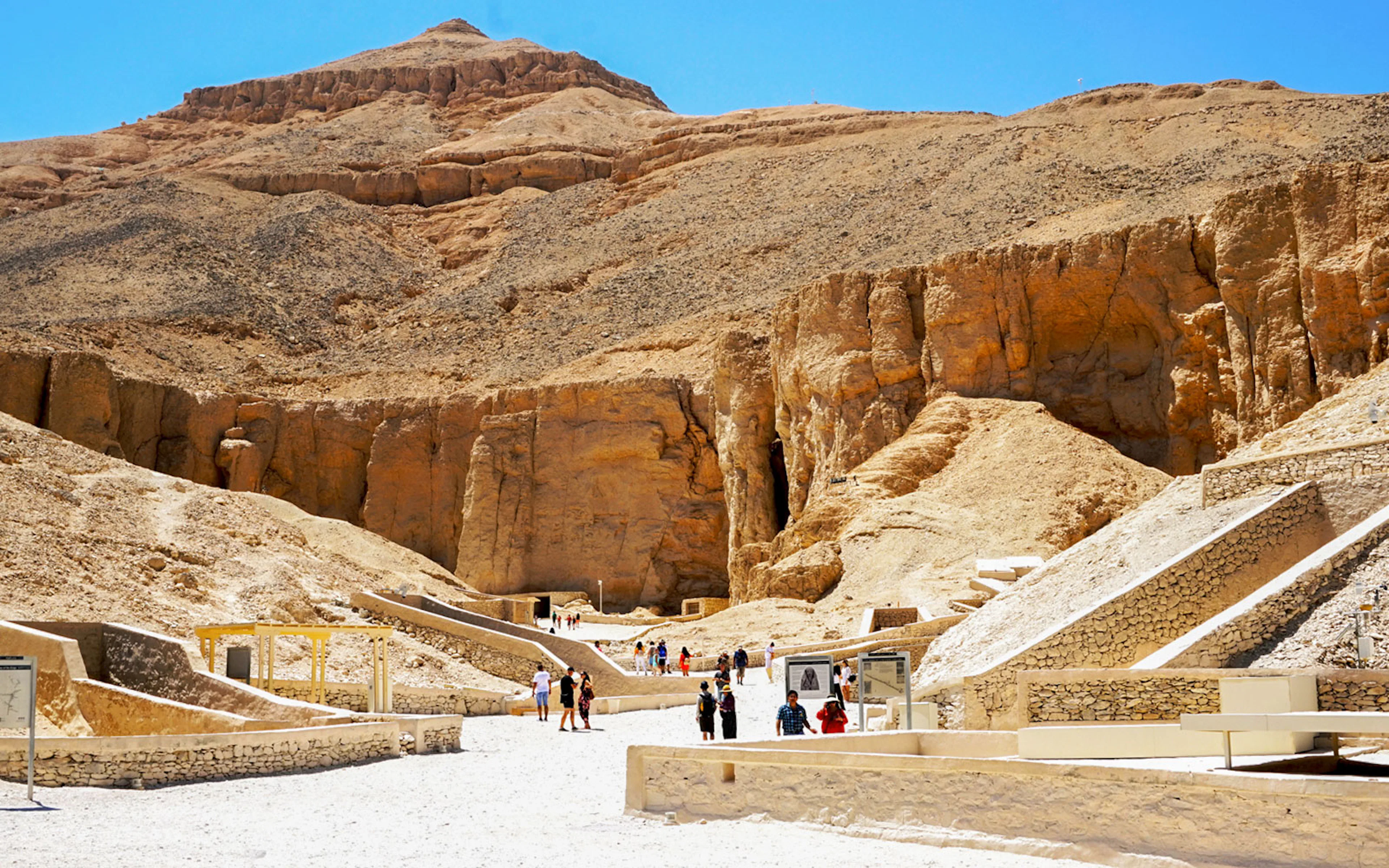 Valley of the Kings entrance with tourists exploring ancient tombs in Luxor, Egypt.