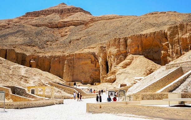 Valley of the Kings entrance with tourists exploring ancient tombs in Luxor, Egypt.