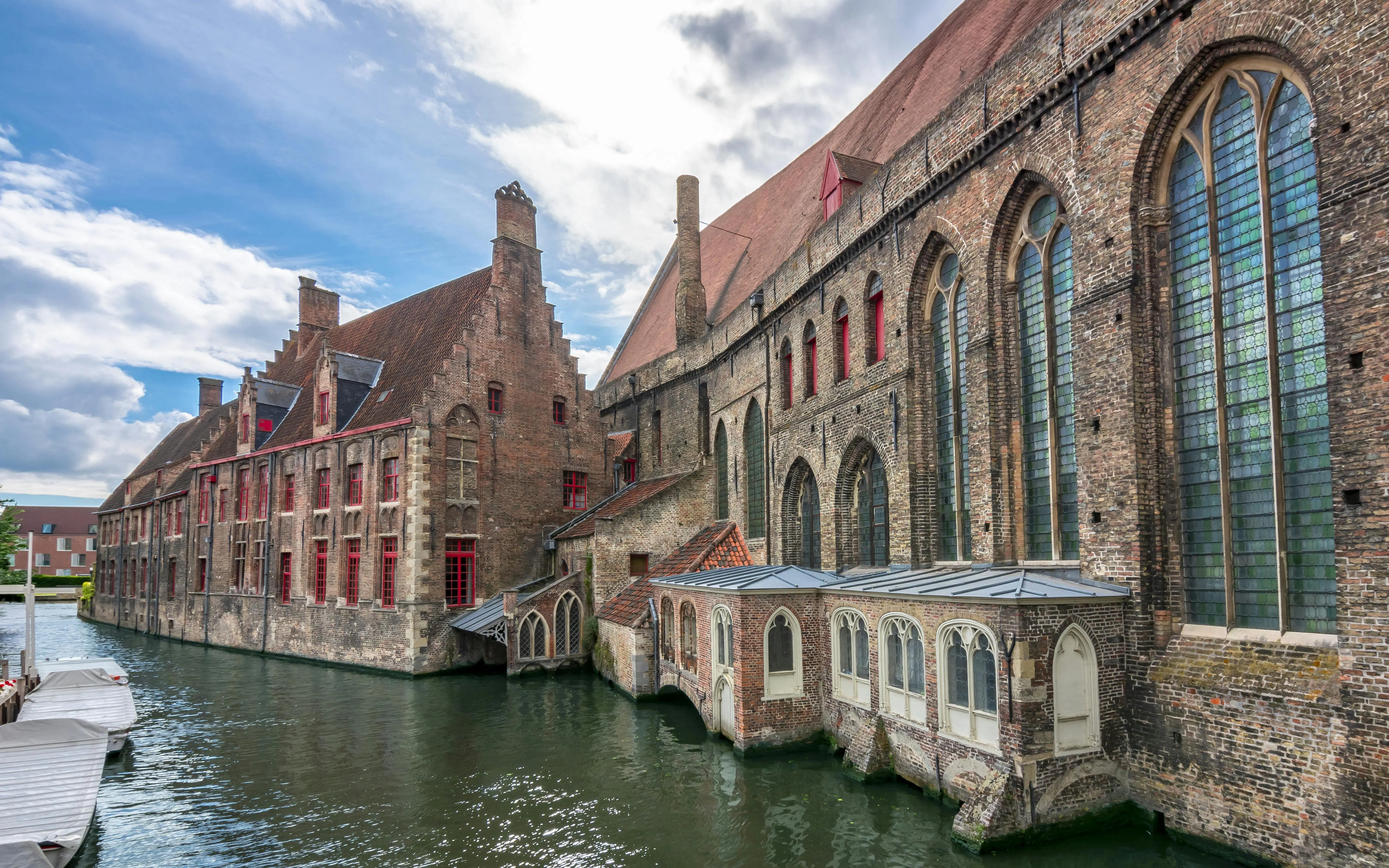 Museum Sint-Janshospitaal in Bruges with historic brick architecture along a canal.