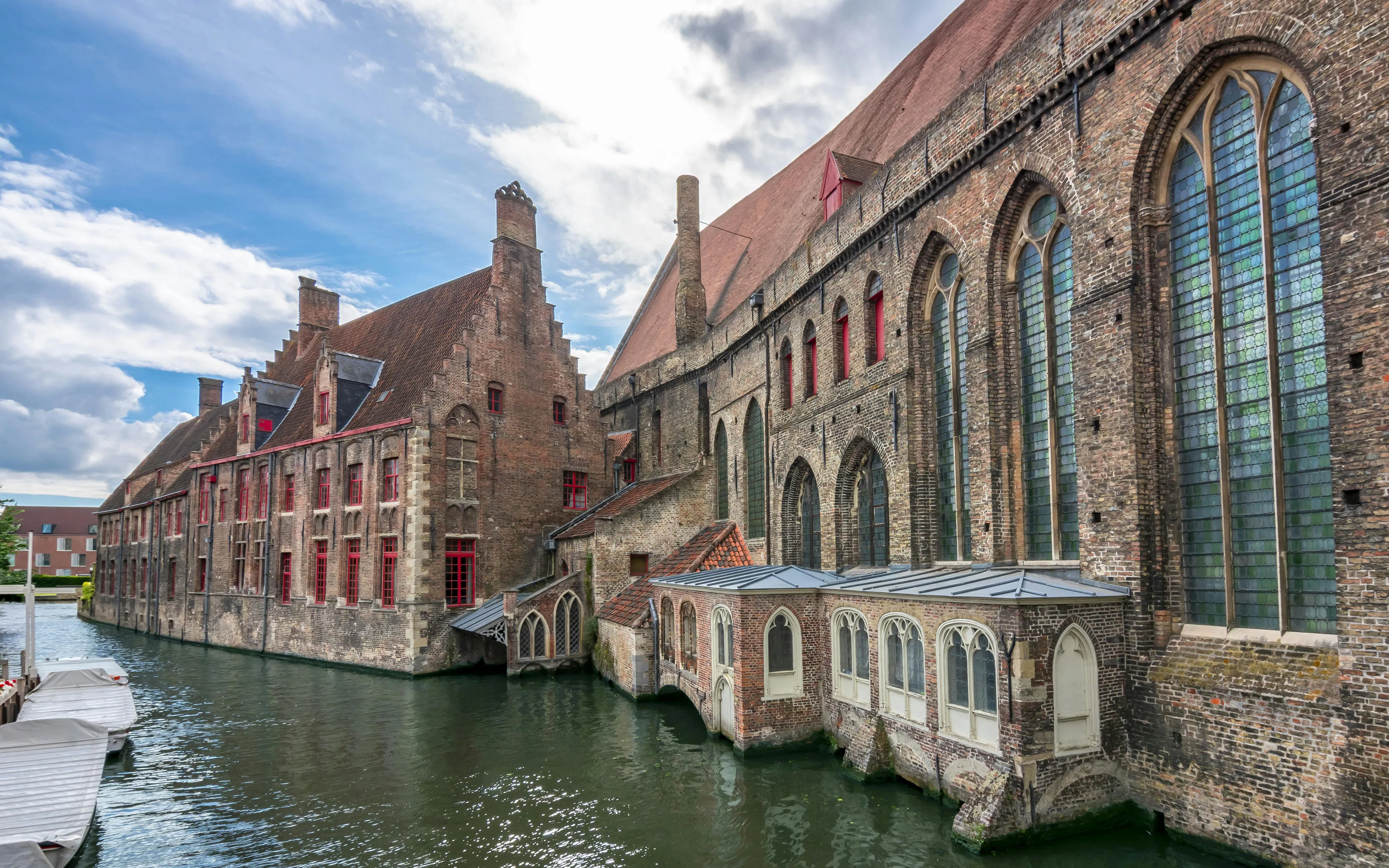 Museum Sint-Janshospitaal in Bruges with historic brick architecture along a canal.
