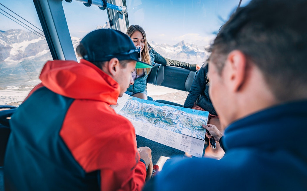 Tourists studying a map inside a cable car during the Matterhorn Glacier Paradise excursion.