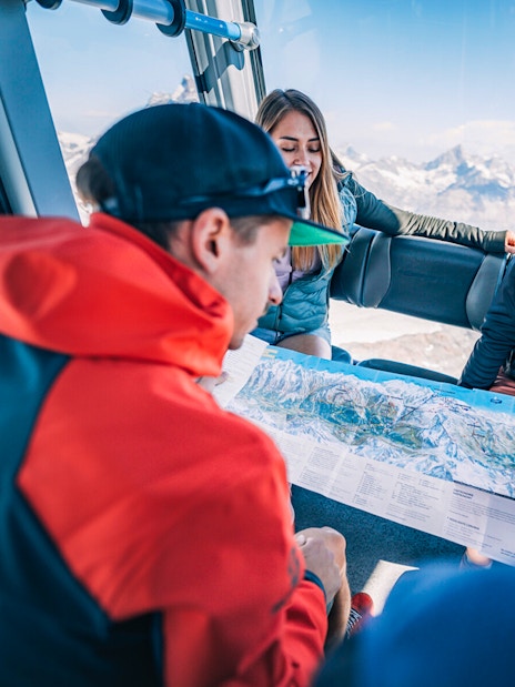 Tourists studying a map inside a cable car during the Matterhorn Glacier Paradise excursion.
