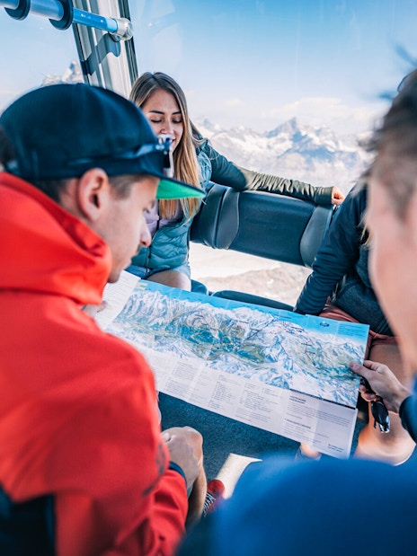 Tourists studying a map inside a cable car during the Matterhorn Glacier Paradise excursion.