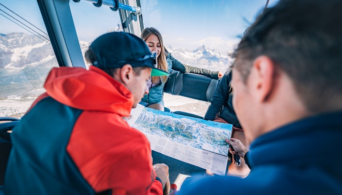 Tourists studying a map inside a cable car during the Matterhorn Glacier Paradise excursion.