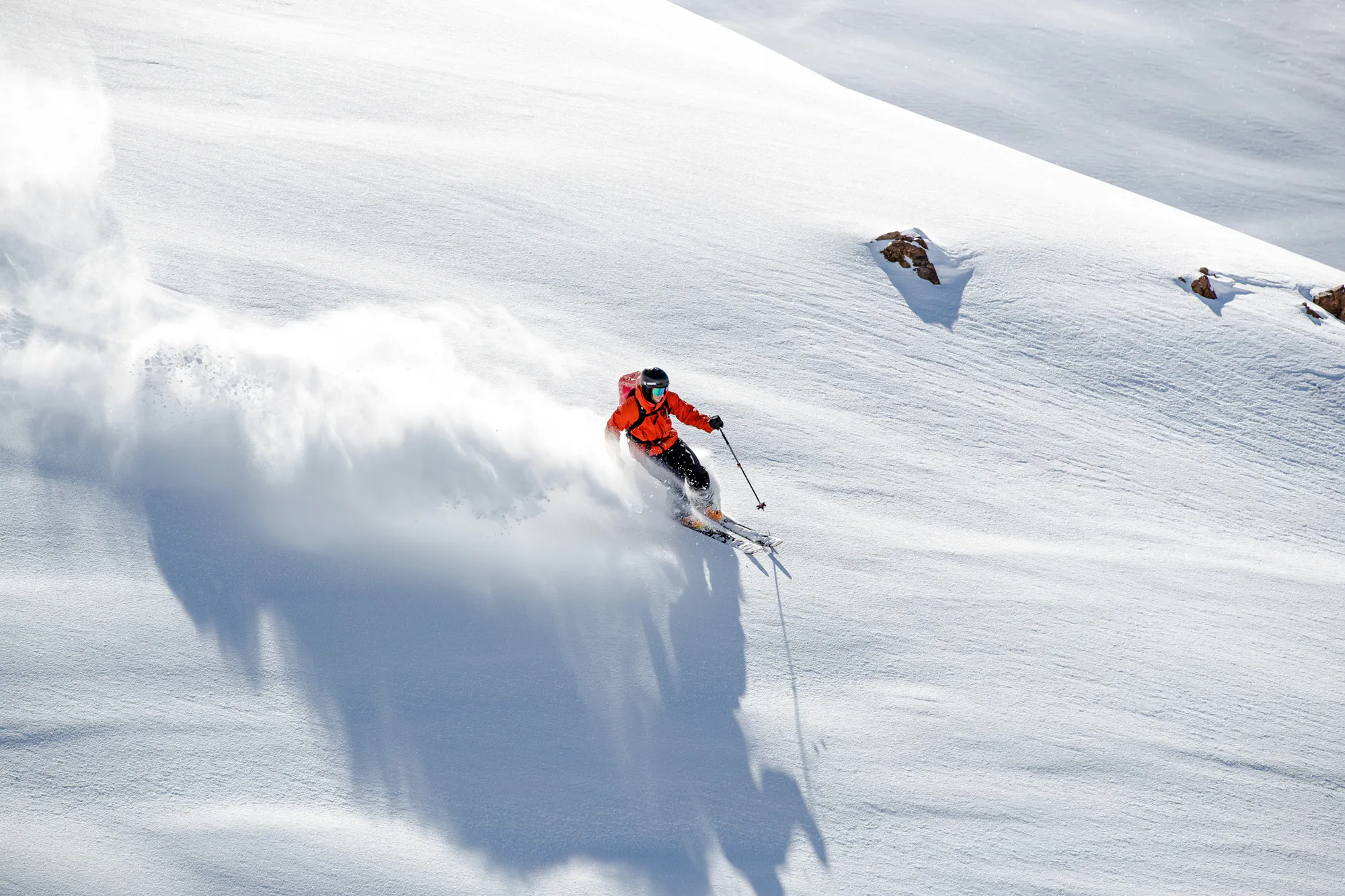 Skier descending snowy slope in Farellones, Santiago, with snow equipment.