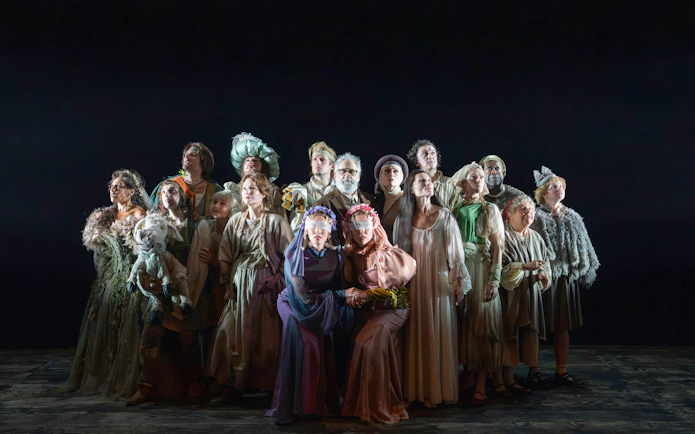 Group of actors in costume on stage for "Into the Woods" performance.