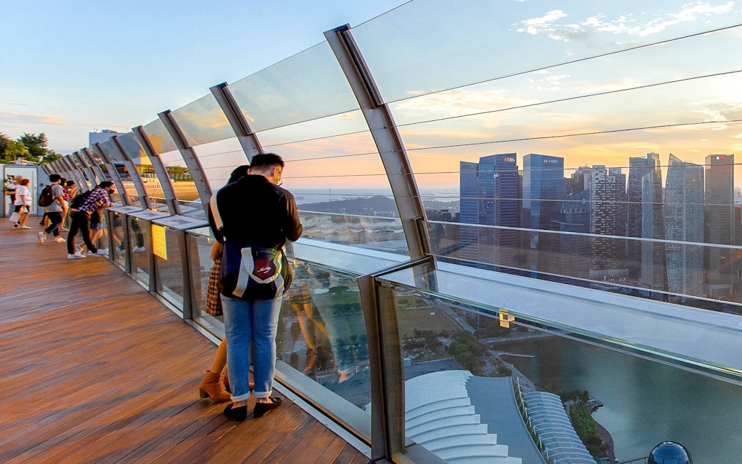 Couple enjoying city view from Marina Bay Sands SkyPark Observation Deck, Singapore.