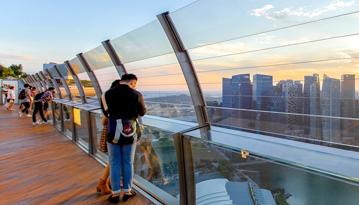Couple enjoying skyline view from Marina Bay Sands SkyPark Observation Deck, Singapore.