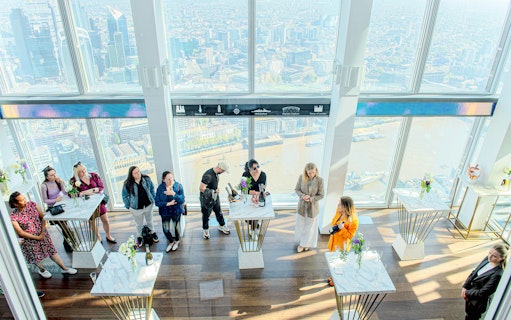 Guests enjoying champagne with a view of London from The Shard.