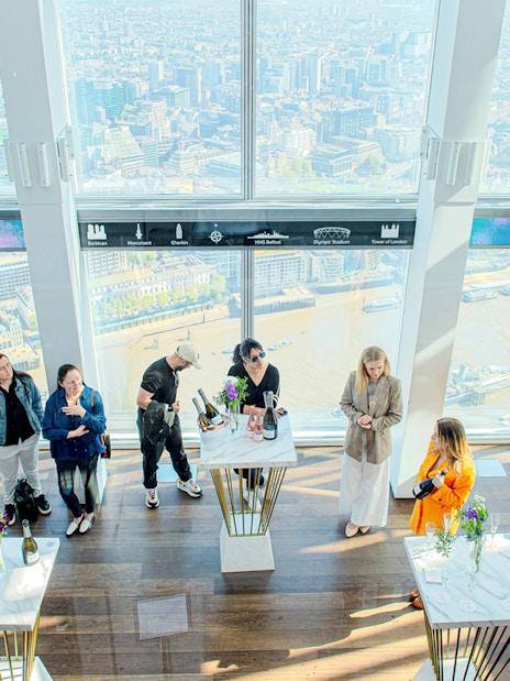 Guests enjoying champagne with a view of London from The Shard.