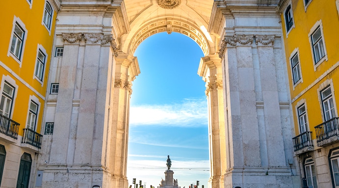 Rua Augusta Arch in Lisbon with cobblestone street and distant statue view.