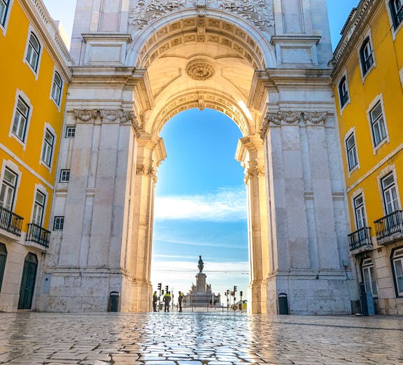 Rua Augusta Arch in Lisbon with cobblestone street and distant statue view.