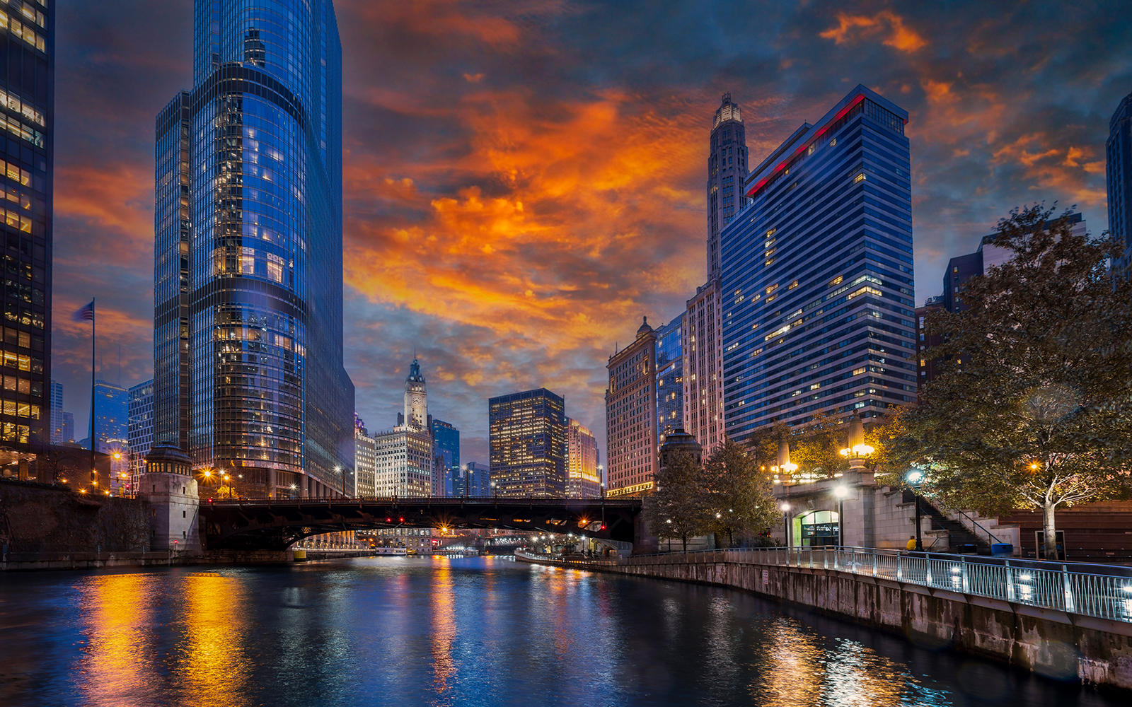 Chicago River with skyscrapers and bridge at sunset during architecture cruise.