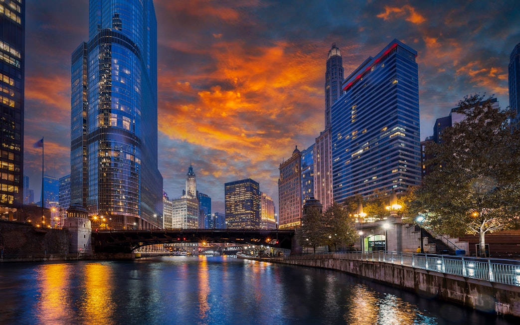 Chicago River with skyscrapers and bridge at sunset during architecture cruise.
