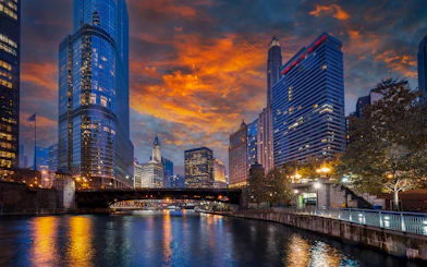 Chicago River with skyscrapers and bridge at sunset during architecture cruise.