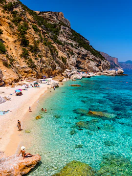 Cala Mariolu beach with clear turquoise water and rocky cliffs in Sardinia, Italy.