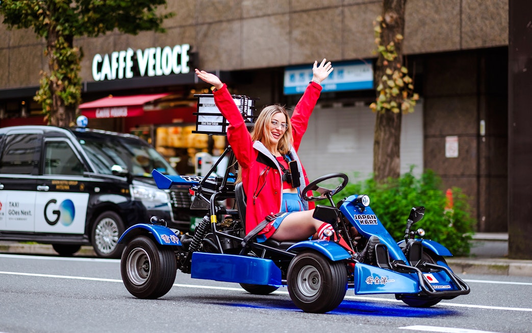 Woman enjoying go-kart ride in Shibuya during Tokyo Tower tour.