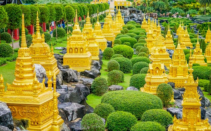 Golden pagodas and manicured greenery at Nong Nooch Tropical Garden, Thailand.