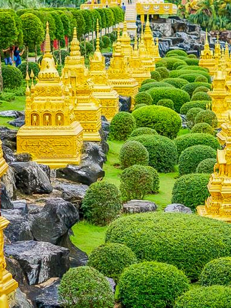 Golden pagodas and manicured greenery at Nong Nooch Tropical Garden, Thailand.