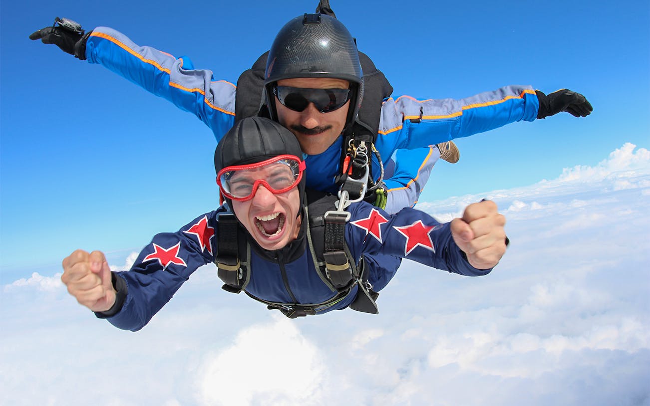 Tandem skydive over Abu Dhabi with two people in freefall, capturing excitement.
